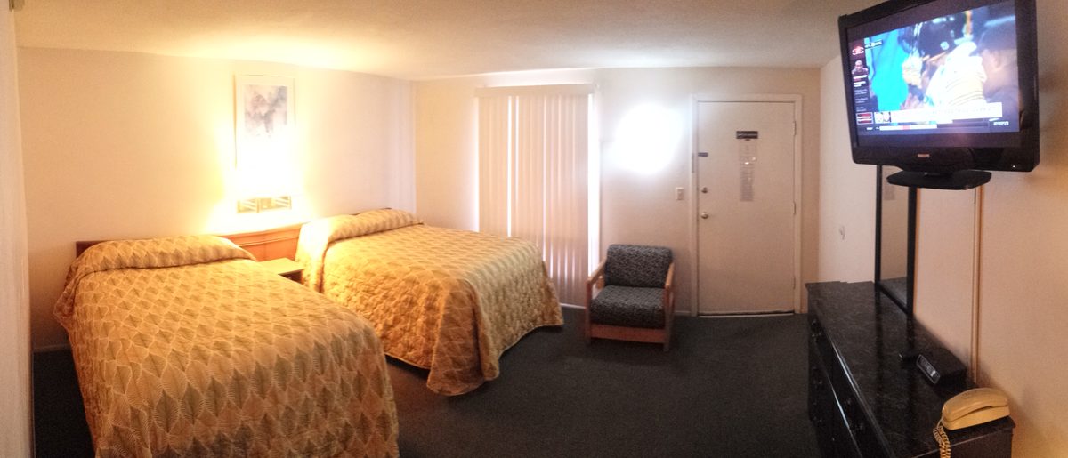 Bright guest room with two beds near the entry