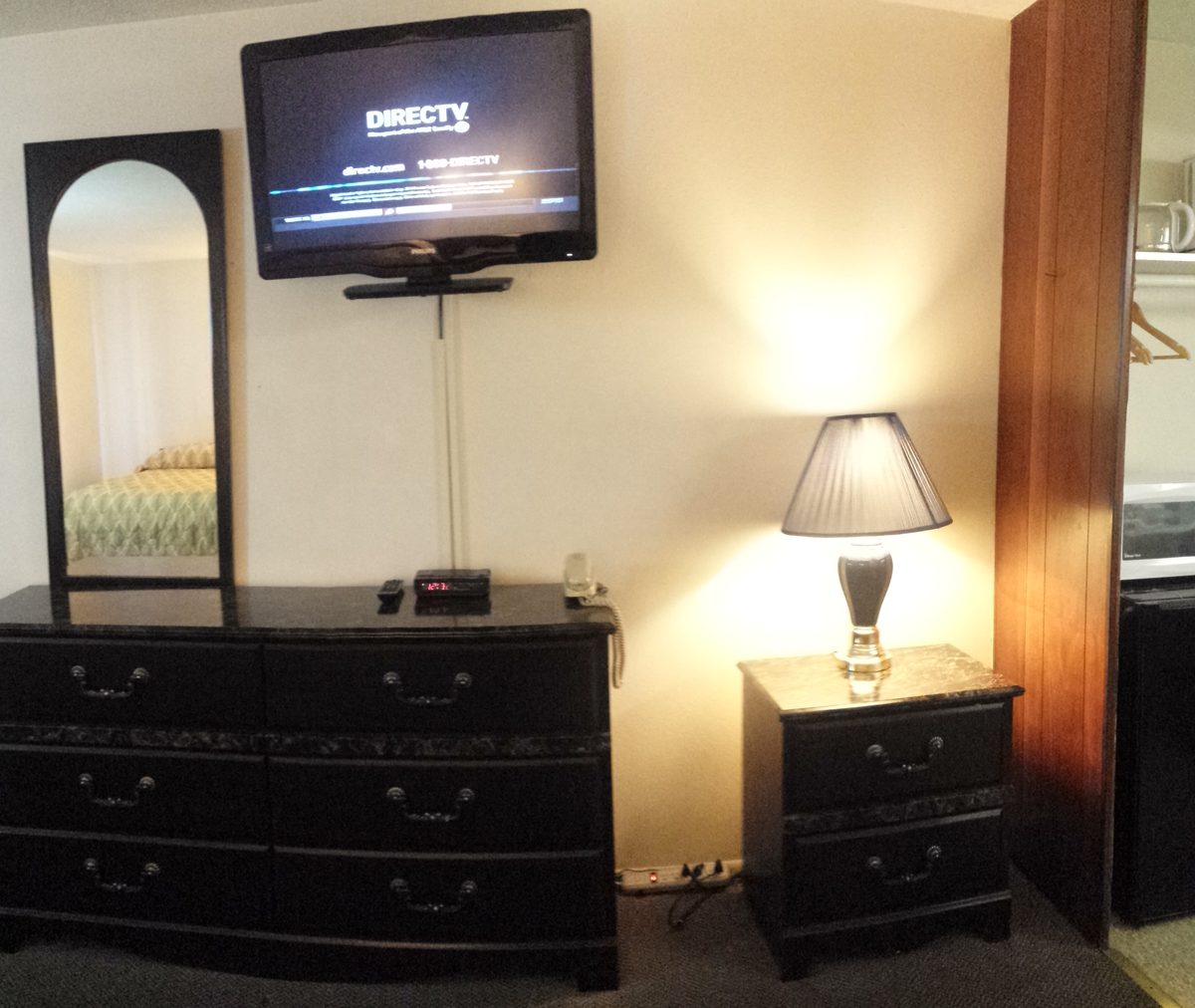 Guest room with flat-screen TV, dresser, and mini-fridge